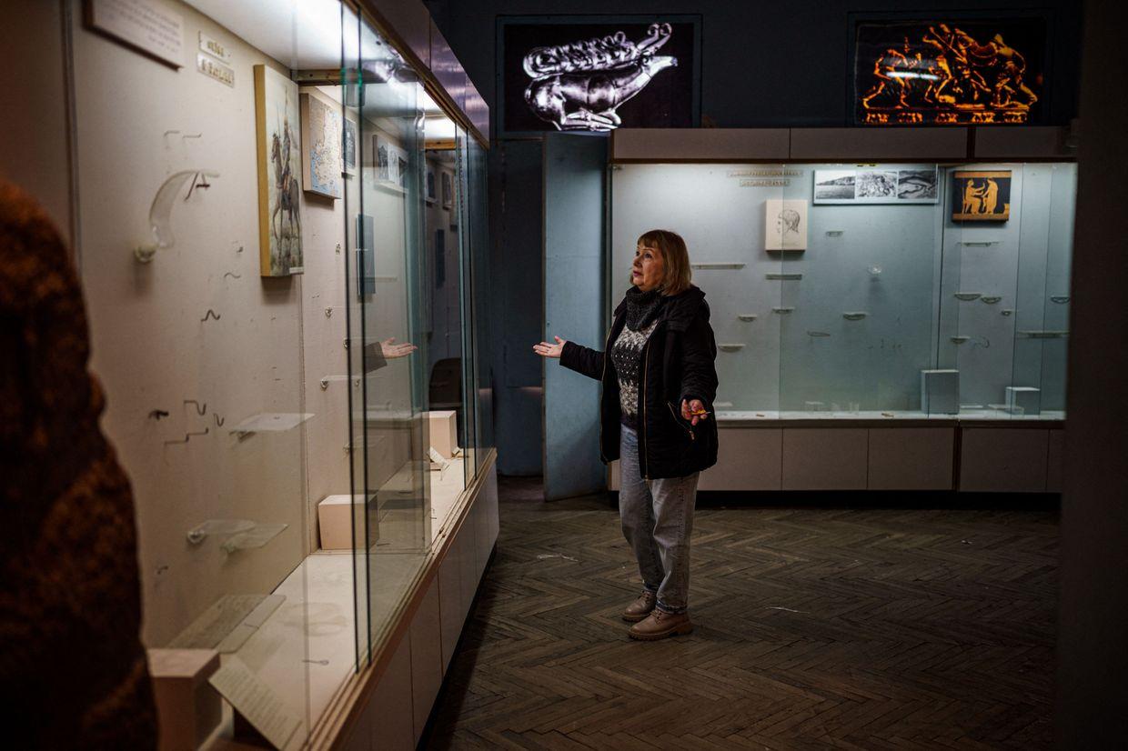 The interim director of the Kherson Regional Museum stands in front of empty display cases looted by Russian forces, in Kherson, Ukraine