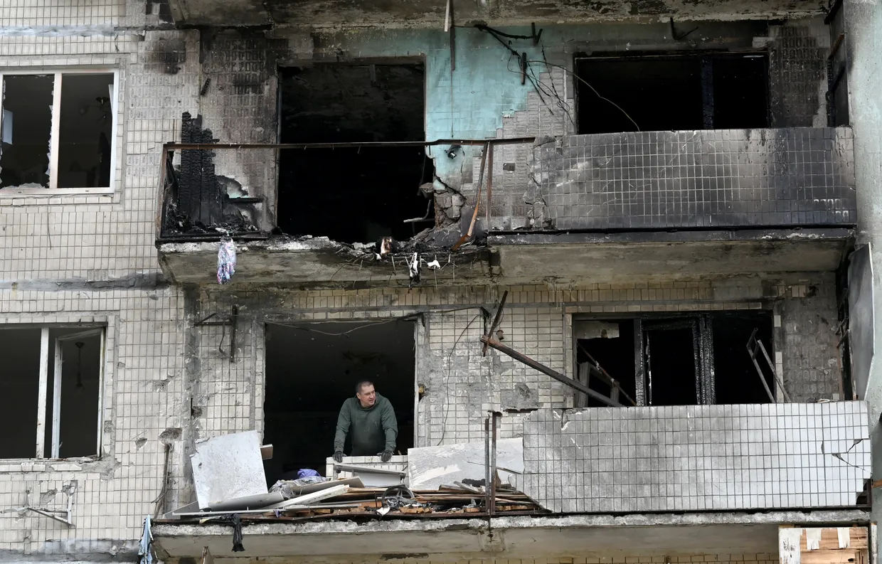 A local resident of a damaged residential building looks on as he clears debris following a Russian strike in Kyiv in May 2025, amid the Russian invasion in Ukraine
