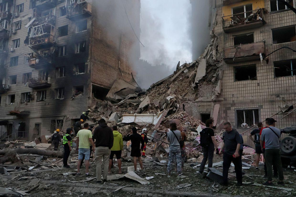 People gather near a residential building in Solomianskyi district, where an entire section was destroyed by a Russian missile strike in Kyiv, Ukraine, June 2025