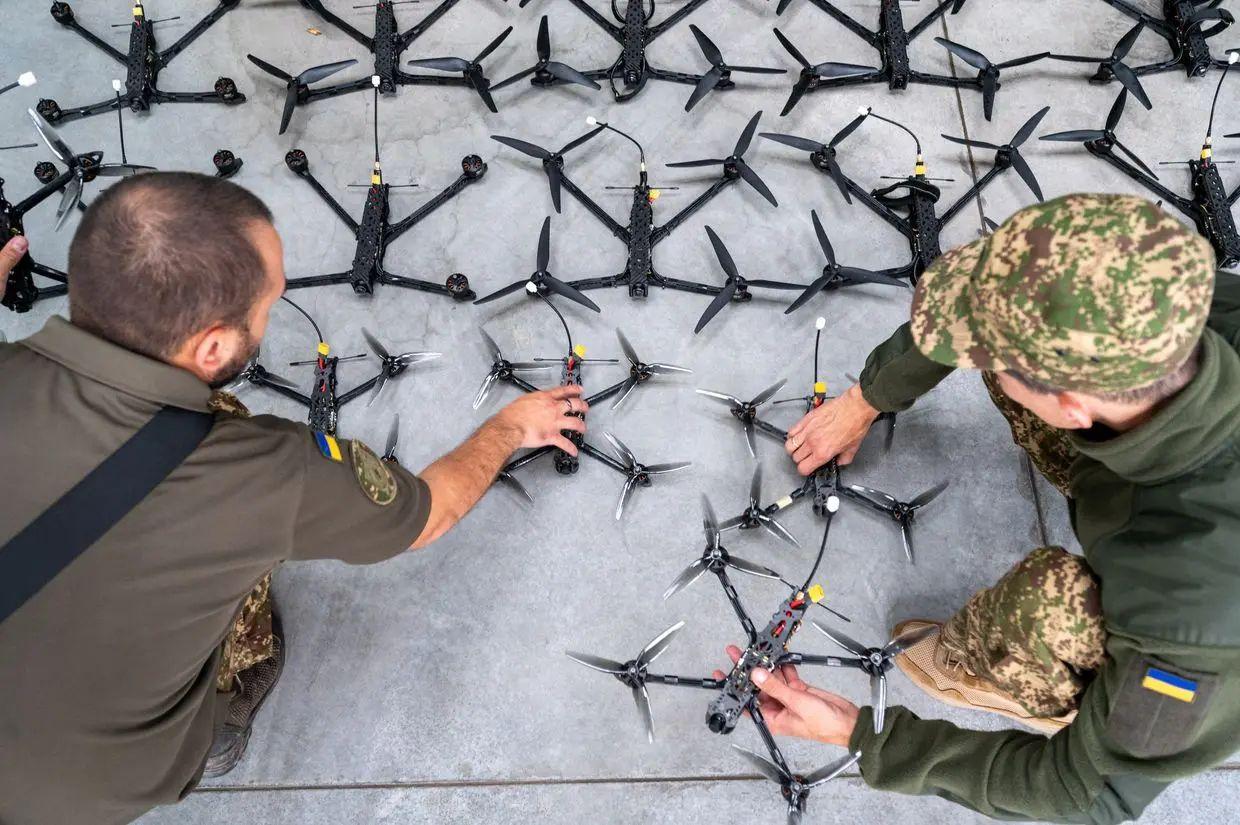 [Illustrative photo] Soldiers of Ukrainian rmed Forces inspect FPV drones during the handover from the volunteer organization in Lviv, Ukraine