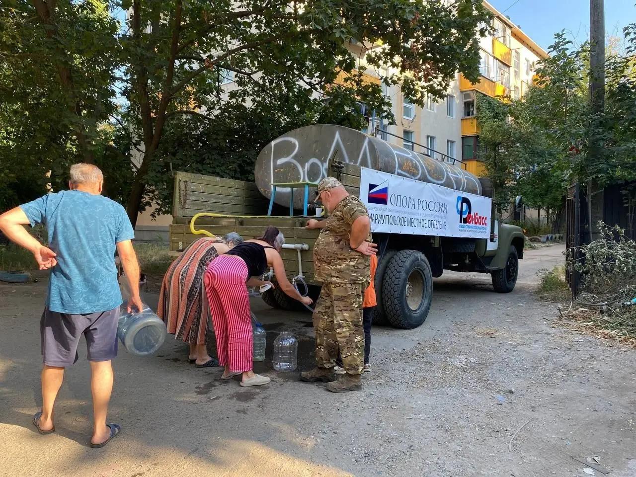 People queue for a water distribution truck in Mariupol, Donetsk Oblast, Aug 2025