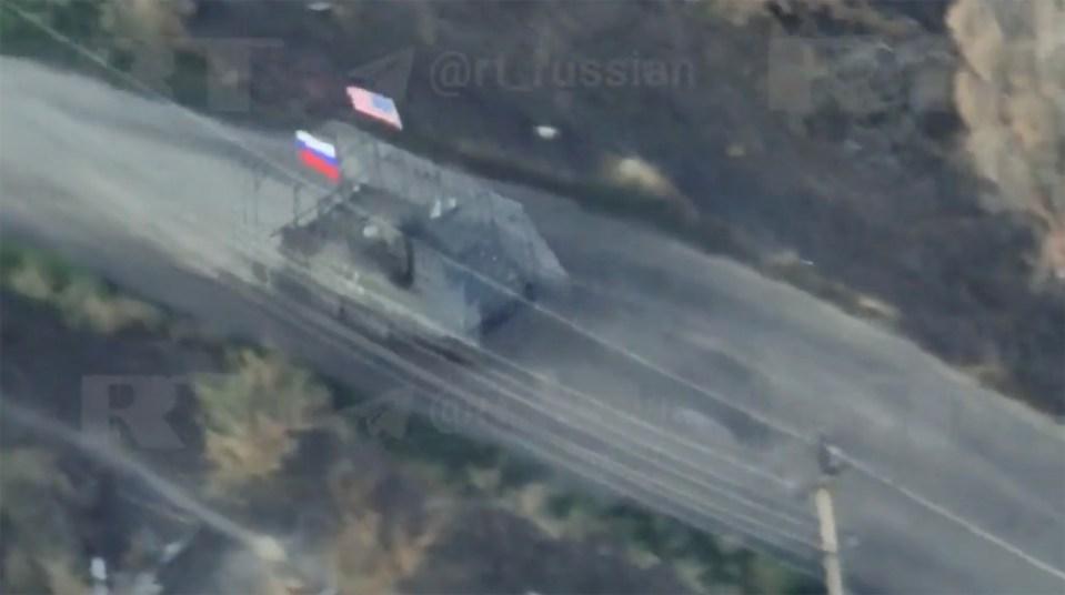 A U.S.-made M113 armored personnel carrier with Russian and American flags attacks Ukrainian positions in Zaporizhzhia Oblast in footage published on Aug. 18, 2025