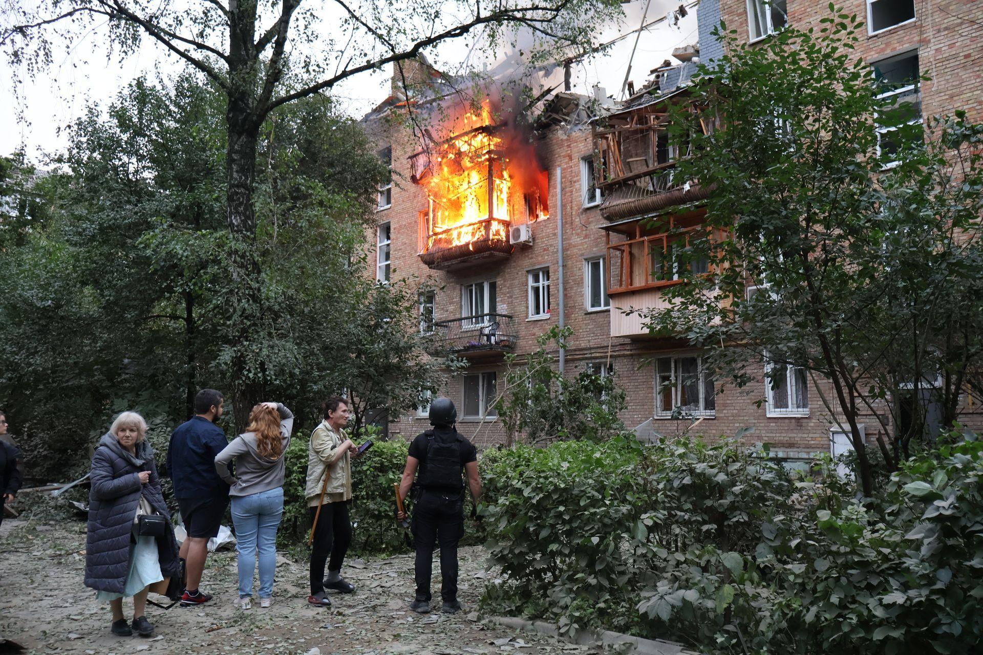 Locals gather near a residential apartment building in the Solomianskyi District damaged by a Russian missile strike in Kyiv, Ukraine, July 2025