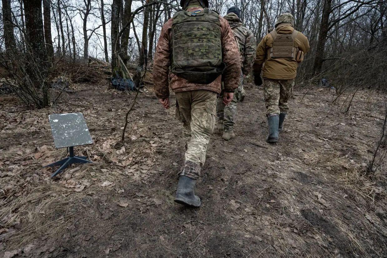 [Illustrative photo] Soldiers of Ukraine's 95th Brigade walk past a Starlink satellite internet receiver