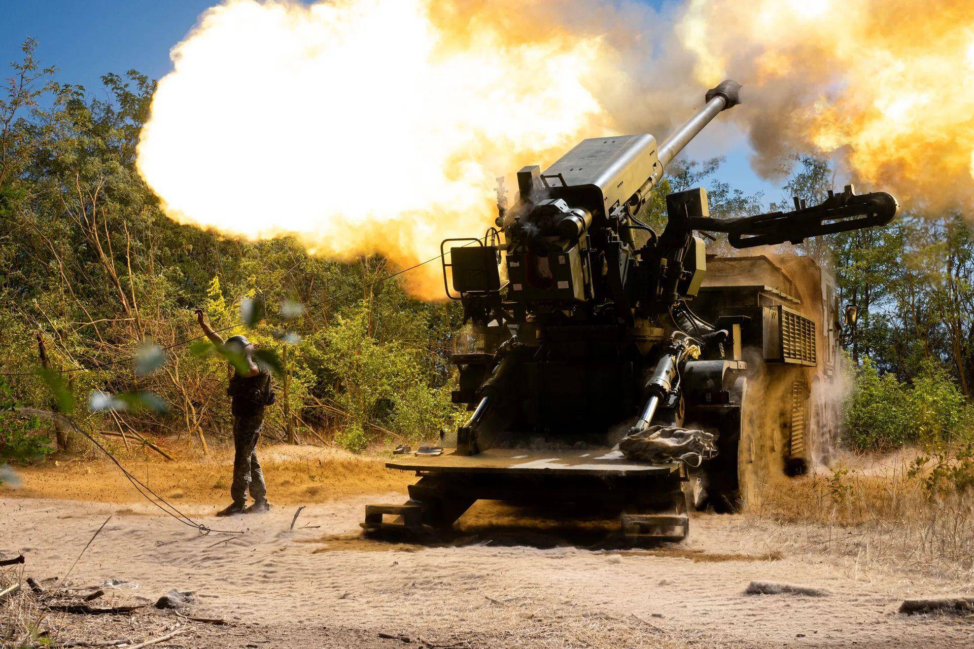 A soldier of an artillery crew stands by a 2S22 Bohdana self-propelled howitzer that is fired during a combat mission in the Zaporizhzhia sector, Ukraine, Summer 2025